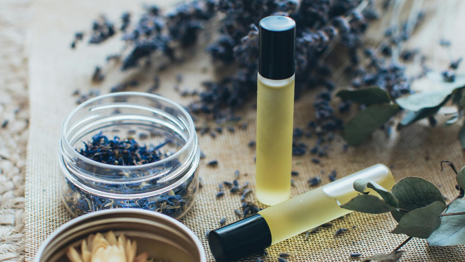 Cosmetic products with lavender and eucalyptus on a textured surface